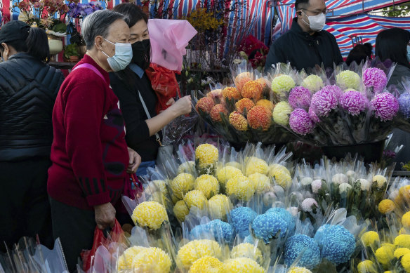 Les acheteurs regardent des bouquets de fleurs lors d'un marché aux fleurs du Nouvel An lunaire dans le quartier de Causeway Bay à Hong Kong