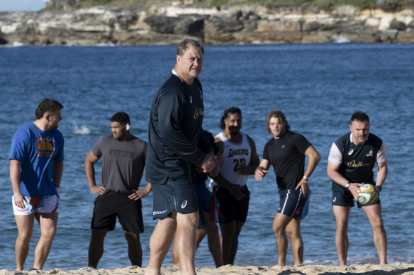 Neal Hatley met en place un exercice pendant que les nageurs traversent la plage de Coogee en arrière-plan.