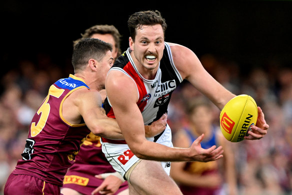 Zaine Cordy des Saints tente de se détacher de la défense de Dayne Zorko des Lions.
