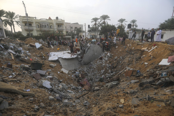 Des Palestiniens inspectent les dégâts d'une maison détruite qui a été touchée par une frappe aérienne israélienne.