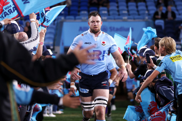 La star des Waratahs, Jed Holloway, traverse un tunnel sous les encouragements des juniors.