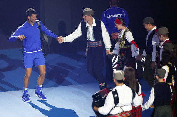 Djokovic danse le kolo avec une troupe de danse serbe lors d'un match de charité à la Rod Laver Arena avant l'Open d'Australie.