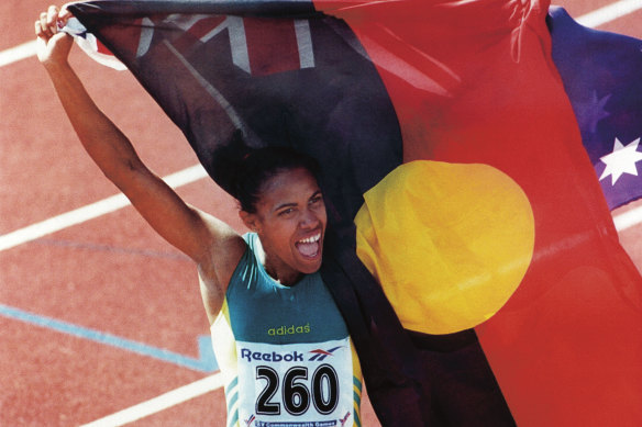 Cathy Freeman porte le drapeau autochtone aux côtés de celui de l'Australie aux Jeux du Commonwealth de 1994 au Canada.