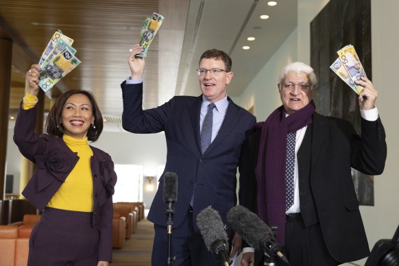 Gee (au centre), avec ses collègues députés indépendants Dai Le et Bob Katter, pose avec de la fausse monnaie après s'être adressé aux médias lors d'une conférence de presse.