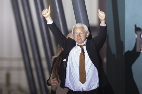 Julian Assange a levé ses pouces en descendant de l'avion sous les applaudissements à Canberra mercredi soir.