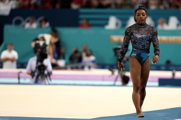 Simone Biles réagit après avoir terminé sa routine d'exercice au sol.
