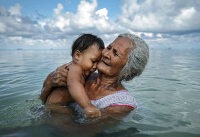 Suega Apelu donne le bain à un enfant à Tuvalu, pays confronté aux conséquences disproportionnées du changement climatique.