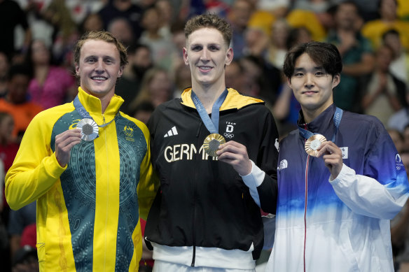 Le médaillé d'argent Elijah Winnington (à gauche) avec le médaillé d'or Lukas Martens d'Allemagne et le médaillé de bronze Kim Woo-min de Corée du Sud après la finale du 400 mètres nage libre masculin à Paris.