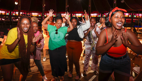 La chorale interprète un numéro improvisé lors d'une vérification du son au Spiegeltent Festival Garden. 