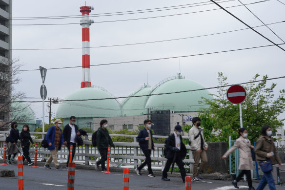 Des piétons passent devant les réservoirs de stockage de Tokyo Gas Co. à Yokohama. Le Japon est devenu plus dépendant des combustibles fossiles après la catastrophe de Fukushima.