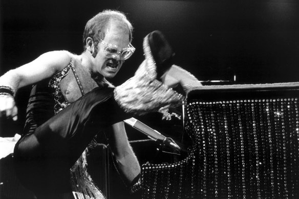 Elton se produit dans l'une de ses combinaisons classiques des années 70.