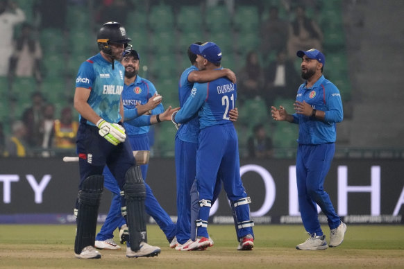 Jos Buttler en Angleterre, à gauche, sort du terrain alors que les joueurs afghans célèbrent après son licenciement lors de leur affrontement mercredi.