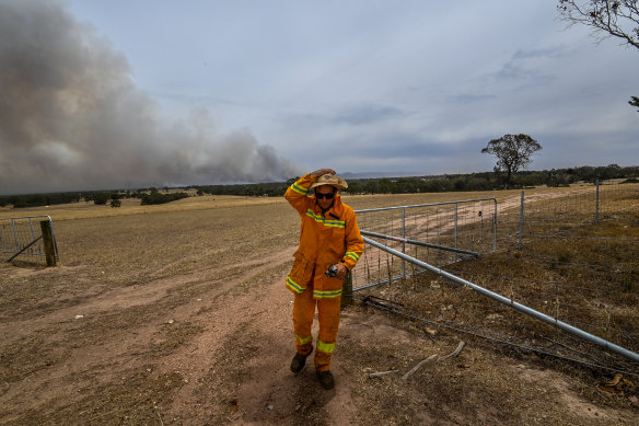 Un agriculteur et une autorité de tir de la campagne surveille l'incendie à côté de sa propriété près des Grampians en décembre.