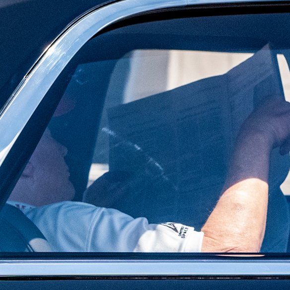 Le président Donald Trump lit le Wall Street Journal alors qu'il revient dans son club Mar-a-Lago du Trump National Golf Club samedi.