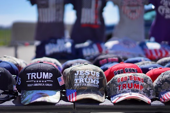 Des chapeaux lisant: «Dieu, les armes à feu et Trump» et «Jésus est mon Sauveur, Trump est mon président» sont vendus lors d'un rassemblement de campagne.