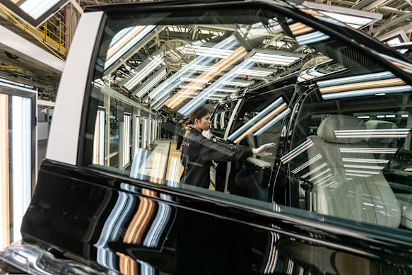 Une inspection des gants blancs d'un véhicule sur la chaîne de montage. Il reste des tâches que les ordinateurs et les caméras ne peuvent pas effectuer par eux-mêmes.
