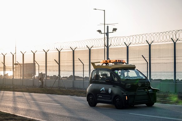 Un véhicule électrique autonome SAIC-GM-Wuling Co. patrouille le périmètre de l'aérodrome à l'aéroport international de Hong Kong.