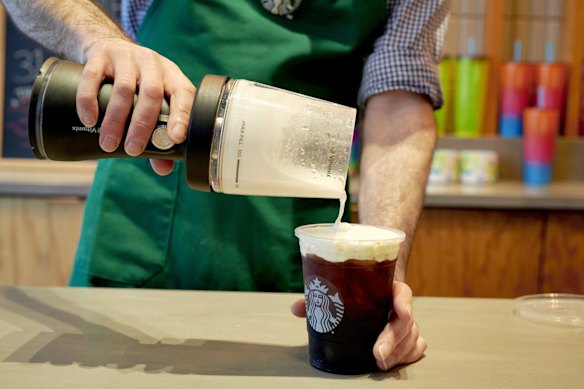 Un barista Starbucks utilise un mélangeur portable pour faire de la mousse froide à New York.