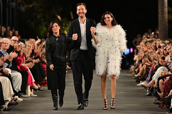 La directrice du design de Carla Zampatti, Tanya Emon Beattie, et le directeur général Alex Schuman marchent sur la piste avec un modèle dans l'un des conceptions du label.