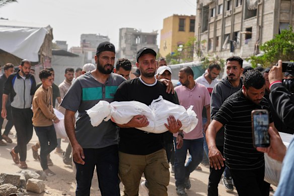 Saleh Zenati, porte le corps de son neveu en nourrisson Khalid, qui a été tué par une frappe aérienne de l'armée israélienne ce mois-ci.