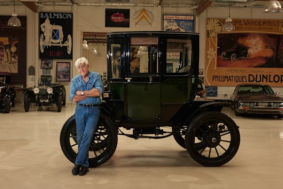Jay Leno avec un Baker Electric 1909 restauré dans une installation pour sa grande collection d'automobiles à Burbank, en Californie.