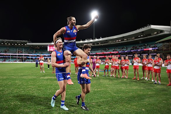 Marcus Bontempelli des Bulldogs célèbre la victoire et est présidé par le terrain par Aaron Naughton et Tom Liberatore des Bulldogs.