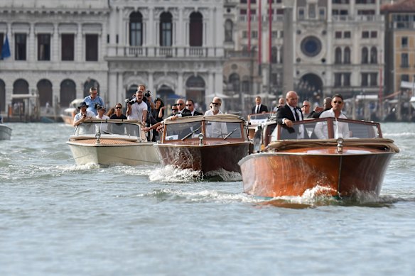 Le bateau transportant Jeff Bezos (au centre) passe devant le carré St Mark avant le mariage prévu.