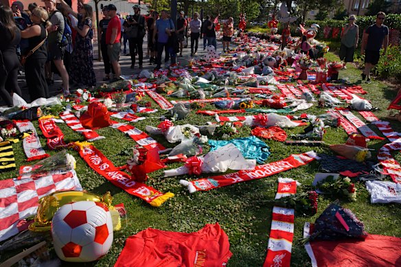 Les fans de football se tiennent à côté des hommages à la mémoire du joueur de Liverpool Diogo Jota au stade Anfield.