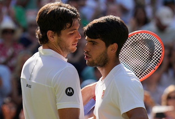 Alcaraz et Taylor Fritz se rencontrent au filet après leur bataille en quatre sets.