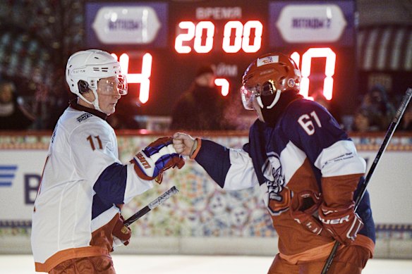 Le président russe Vladimir Poutine, à gauche, et Vladimir Potanin se félicitent après un match de hockey à Moscou en 2018.