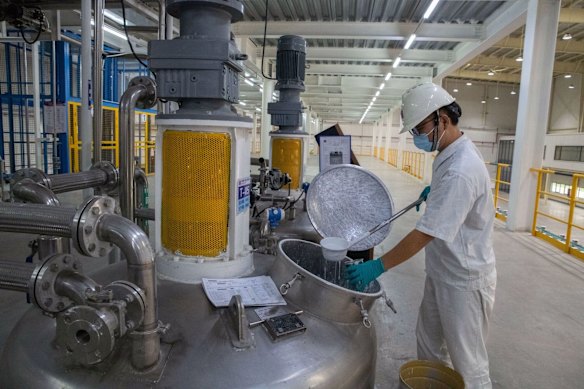 Un travailleur recueille un échantillon de peinture pour un contrôle de qualité à l'usine de peinture Nippon à Qingyuan, en Chine.