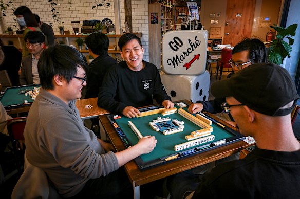 Michael Zhao, au centre, l'organisateur d'une soirée hebdomadaire de mahjong japonais au Marche Board Game Cafe de Melbourne.