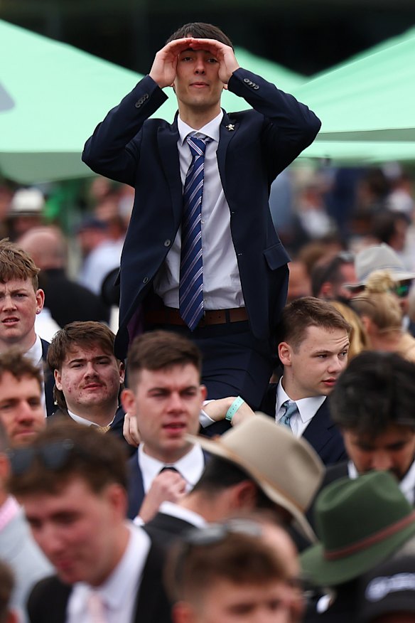 Une mer de jeunes hommes attendant de trouver leur place à la mode à l'hippodrome de Flemington le jour de la Coupe.