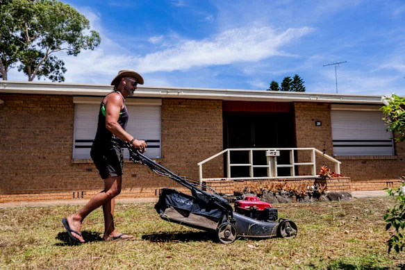 George Tsoukalidis, préposé à l'entretien de la propriété, tond la pelouse d'un client à Greystanes, Sydney, par une chaude journée cette semaine.