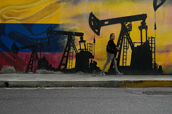 Cette semaine, un habitant passe devant une fresque murale représentant des pompes à pétrole et des puits à Caracas, au Venezuela.