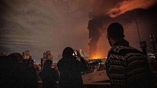 Les habitants de Téhéran regardent les flammes et la fumée s'élever d'une installation de stockage de pétrole frappée par les troupes israéliennes.