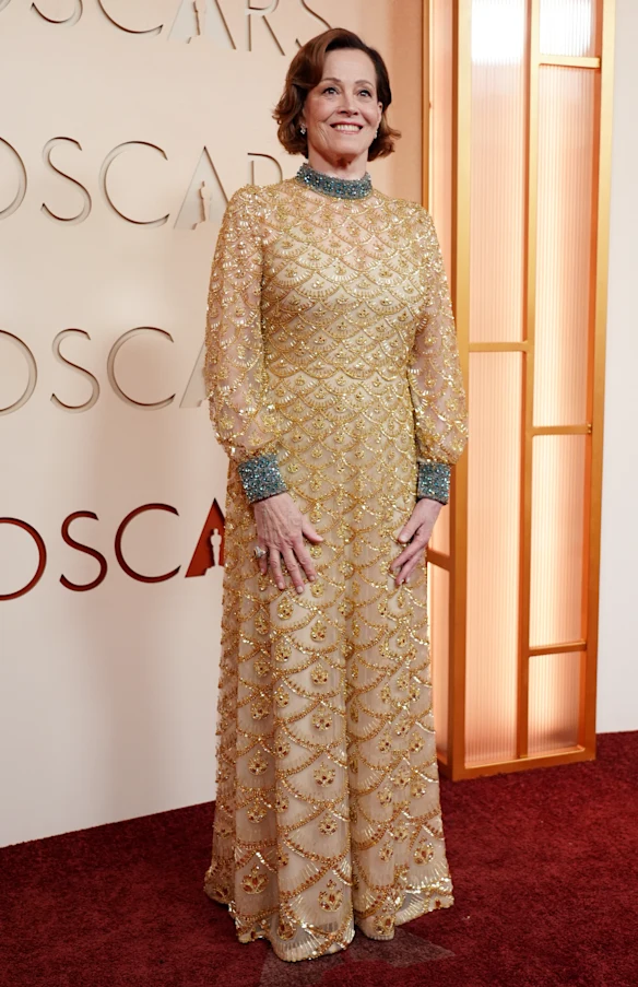Sigourney Weaver canalise un Oscar dans une robe dorée classique.