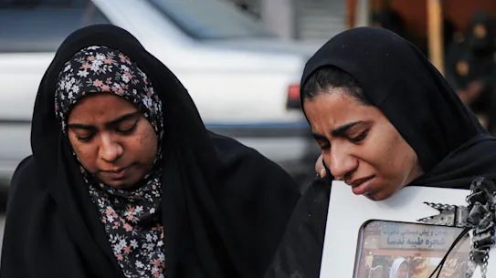 Personnes en deuil lors des funérailles d'un enfant tué lors d'une frappe aérienne en Iran.
