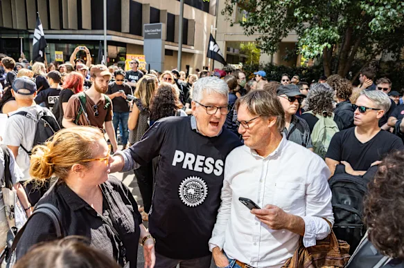 David Marr, animateur de Late Night Live (au centre à gauche), s'adresse au journaliste de four Corners, Angus Grigg, lors d'un rassemblement du personnel devant le siège du radiodiffuseur public à Sydney.