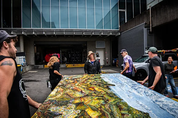Matthew Cook (au centre) décharge son tableau à la Art Gallery of NSW, juste à temps pour y participer au Wynne Prize.