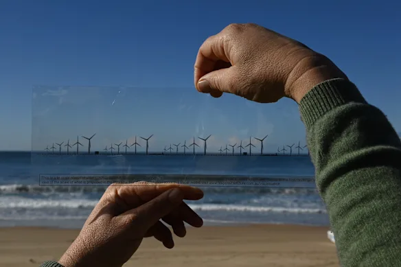 Une impression d'artiste prétendant montrer à quoi ressembleraient des parcs éoliens à 10 km au large de la côte d'Illawarra, telle que distribuée par le groupe Responsible Futures lors d'une réunion publique à Unanderra. À moins que vous n'ayez une deuxième personne pour la tenir à au moins un mètre de distance, cette impression d'artiste fournit une référence visuelle trompeuse sur ce à quoi ressembleraient les éoliennes au large de Wollongong.