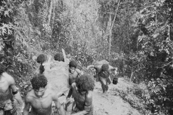 Des porteurs papous (surnommés les anges flous) transportent une victime australienne à travers l'épaisse jungle d'Eora Creek, 1942.