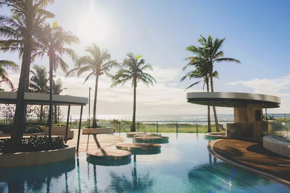La piscine extérieure du Langham est dotée de plages de sable de style lagon et de palmiers.