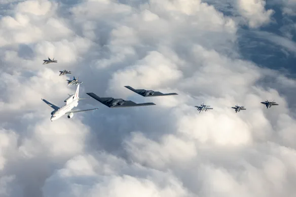 Un Wedgetail de la RAAF (avion blanc à gauche) volant en formation avec des avions à réaction australiens et américains.