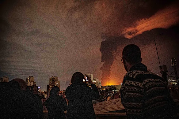 Les habitants de Téhéran regardent les flammes et la fumée s'élever d'une installation de stockage de pétrole frappée par les troupes israéliennes.