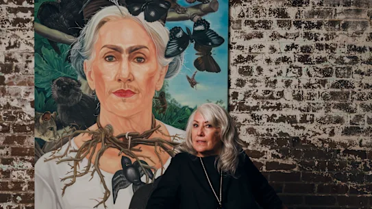 Judith Neilson dans son bureau avec le portrait d'elle réalisé par Guo Jian dans le rôle de l'artiste mexicaine Frida Kahlo.