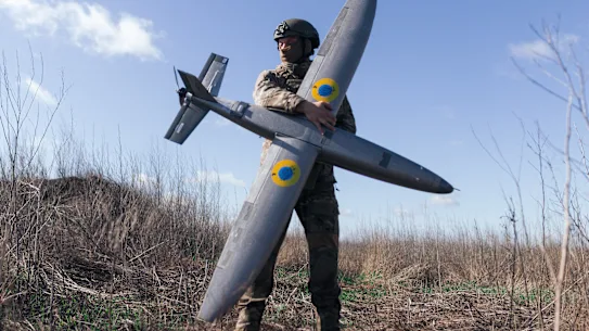 Un soldat ukrainien tient un nouveau modèle de drone d’attaque, reflétant la nature changeante de la guerre moderne.