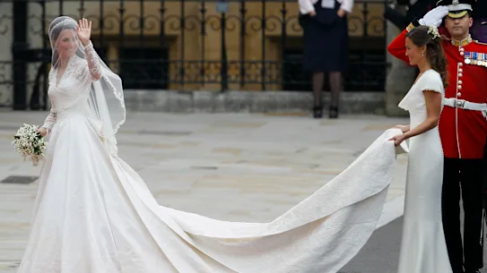 Kate Middleton dans sa robe de mariée Alexander McQueen se prépare à entrer dans l'abbaye de Westminster, avec sa sœur Pippa portant son train.