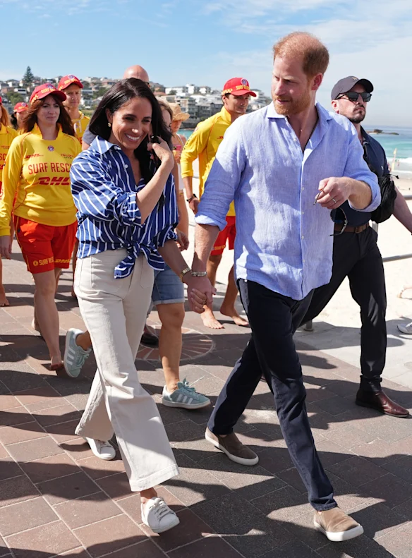 Meghan dans une chemise rayée Matteau et un jean Rolla avec le prince Harry à Bondi Beach.