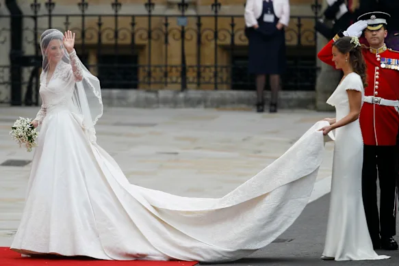 Kate Middleton dans sa robe de mariée Alexander McQueen se prépare à entrer dans l'abbaye de Westminster, avec sa sœur Pippa portant son train.